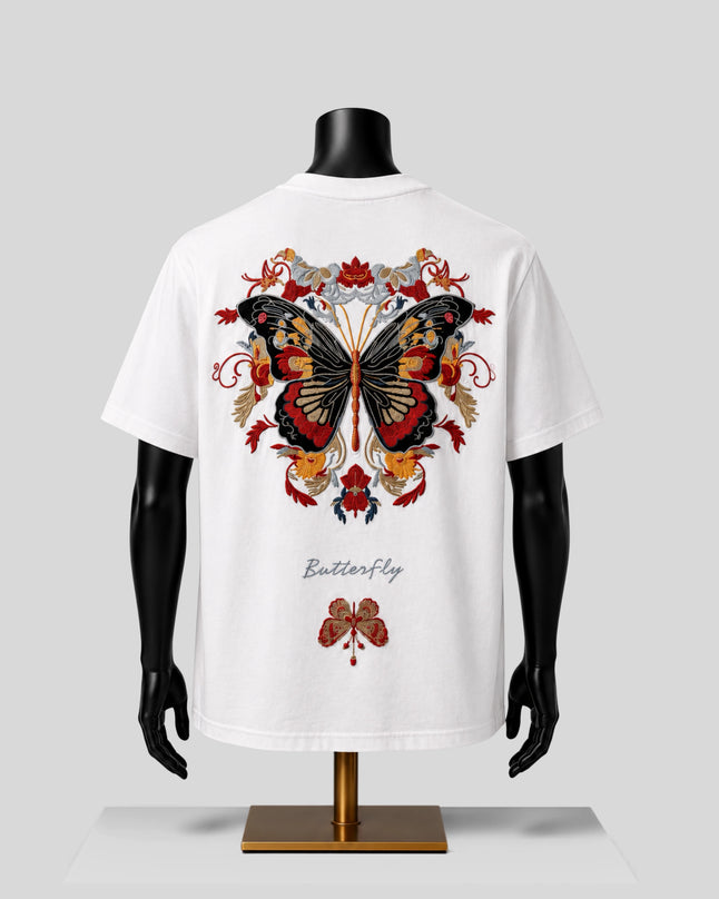 White short-sleeve T-shirt displayed on a black mannequin torso, showing a large colorful butterfly graphic on the back with floral details and the word 'Butterfly' printed below.