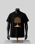 A black short-sleeve t-shirt displayed on a black mannequin torso with a metallic gold tree graphic on the chest, set against a neutral gray background.