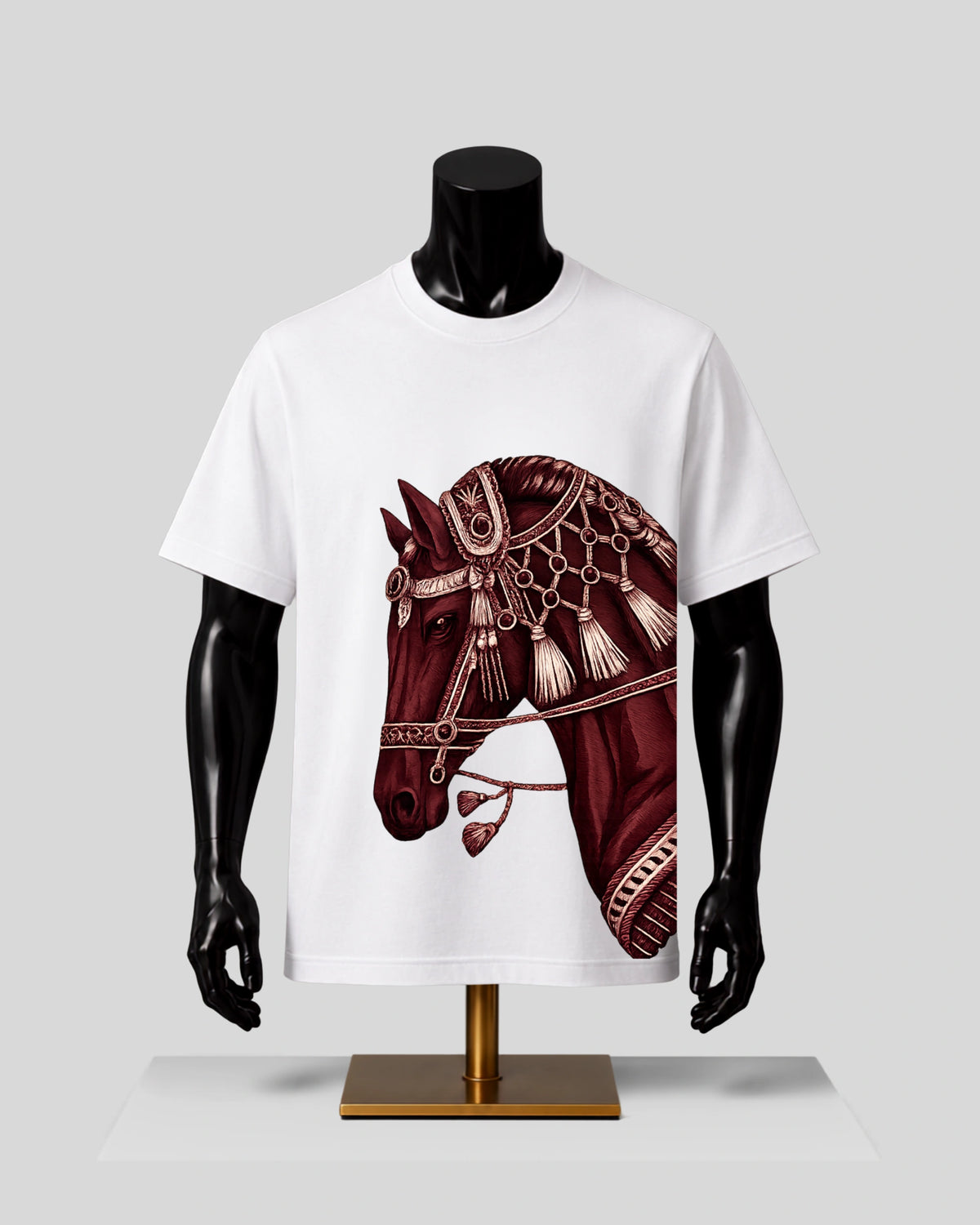 A white short-sleeve crewneck t-shirt displayed on a black mannequin torso. The shirt features a large graphic print of a horse's head in a deep maroon/burgundy color with intricate gold and beige decorative patterns.