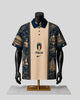 A short-sleeve polo shirt displayed on a black mannequin torso with a gold stand against a light gray background. The shirt has a beige center panel with the Italian crest and the word 'ITALIA' above a Nike swoosh, flanked by dark navy blue panels featuring architectural and historical illustrations.