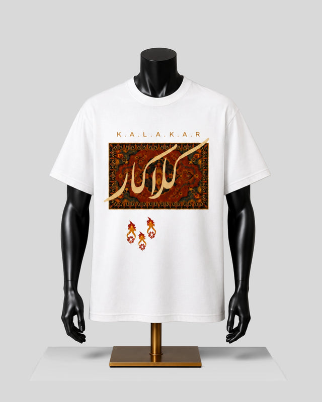 A white short-sleeve graphic T-shirt displayed on a black mannequin torso against a light gray studio background. The shirt features a large rectangular multicolor front print with Arabic calligraphy and the word 'KALAKAR' above it, plus three small red-orange flame-like motifs below.