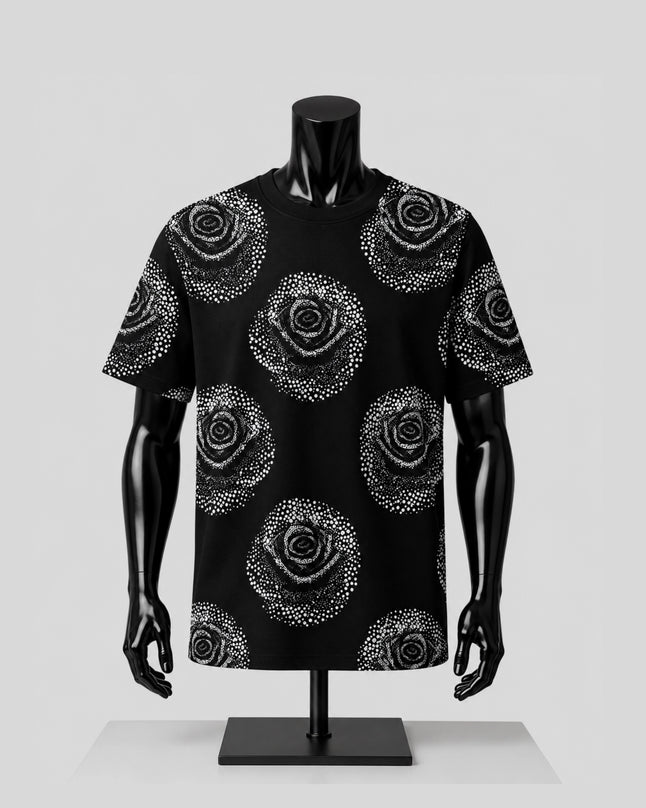 A black short-sleeve t-shirt with a white dotted rose pattern, displayed on a black mannequin torso against a light gray background.
