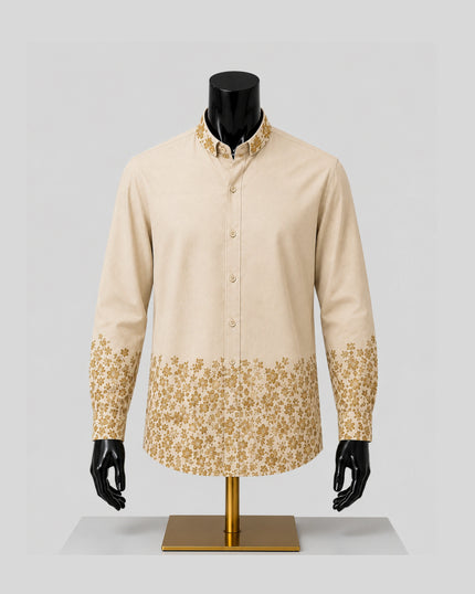 A men's long-sleeve button-up shirt displayed on a black mannequin torso. The shirt is light beige with a gold floral pattern concentrated on the lower half of the body and on the cuffs.