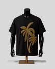 A black short-sleeve T-shirt displayed on a black mannequin torso with a gold palm tree graphic made from small gold embellishments, set against a light gray studio background.