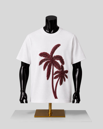 White short-sleeve crewneck T-shirt displayed on a black mannequin torso with a gold stand, featuring a large dark red palm tree graphic on the front.