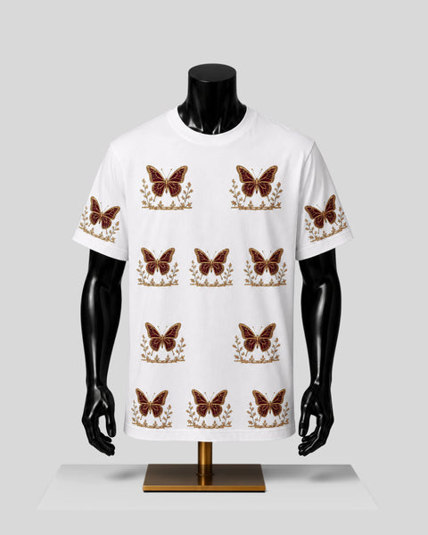A white short-sleeve crewneck t-shirt displayed on a black mannequin torso. The shirt features a repeating pattern of brown butterflies with gold floral borders.