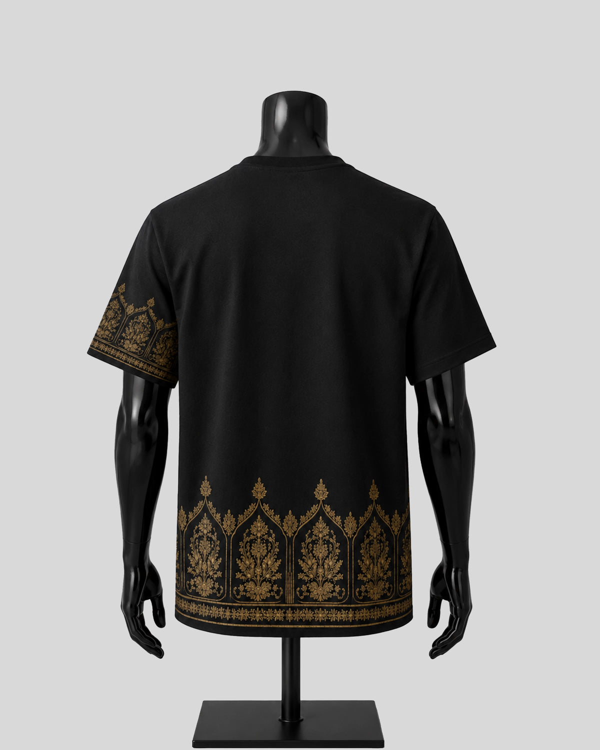 Black short-sleeve t-shirt displayed on a black mannequin from the back, featuring ornate gold patterns along the lower hem and one sleeve, against a light gray background.