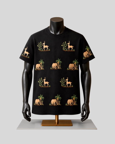 A black short-sleeve t-shirt displayed on a black mannequin torso with arms, featuring a repeating pattern of beige elephants, giraffes, and palm trees with green foliage, set against a light gray background.