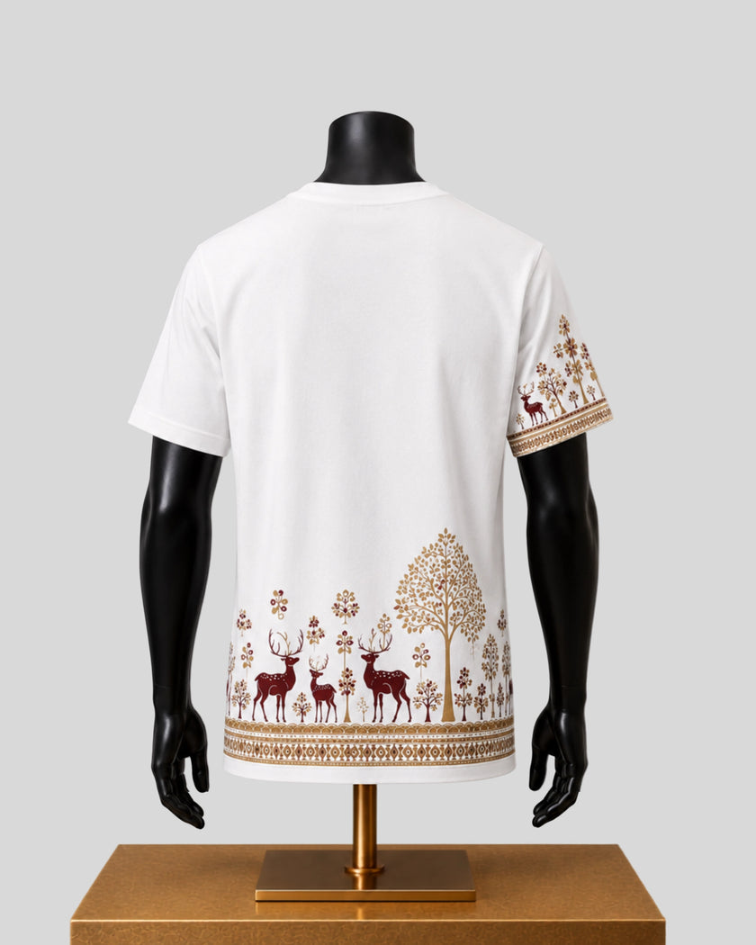 White short-sleeve t-shirt displayed on a black mannequin from the back, featuring a brown forest pattern with deer, trees, and floral motifs along the hem and sleeve.