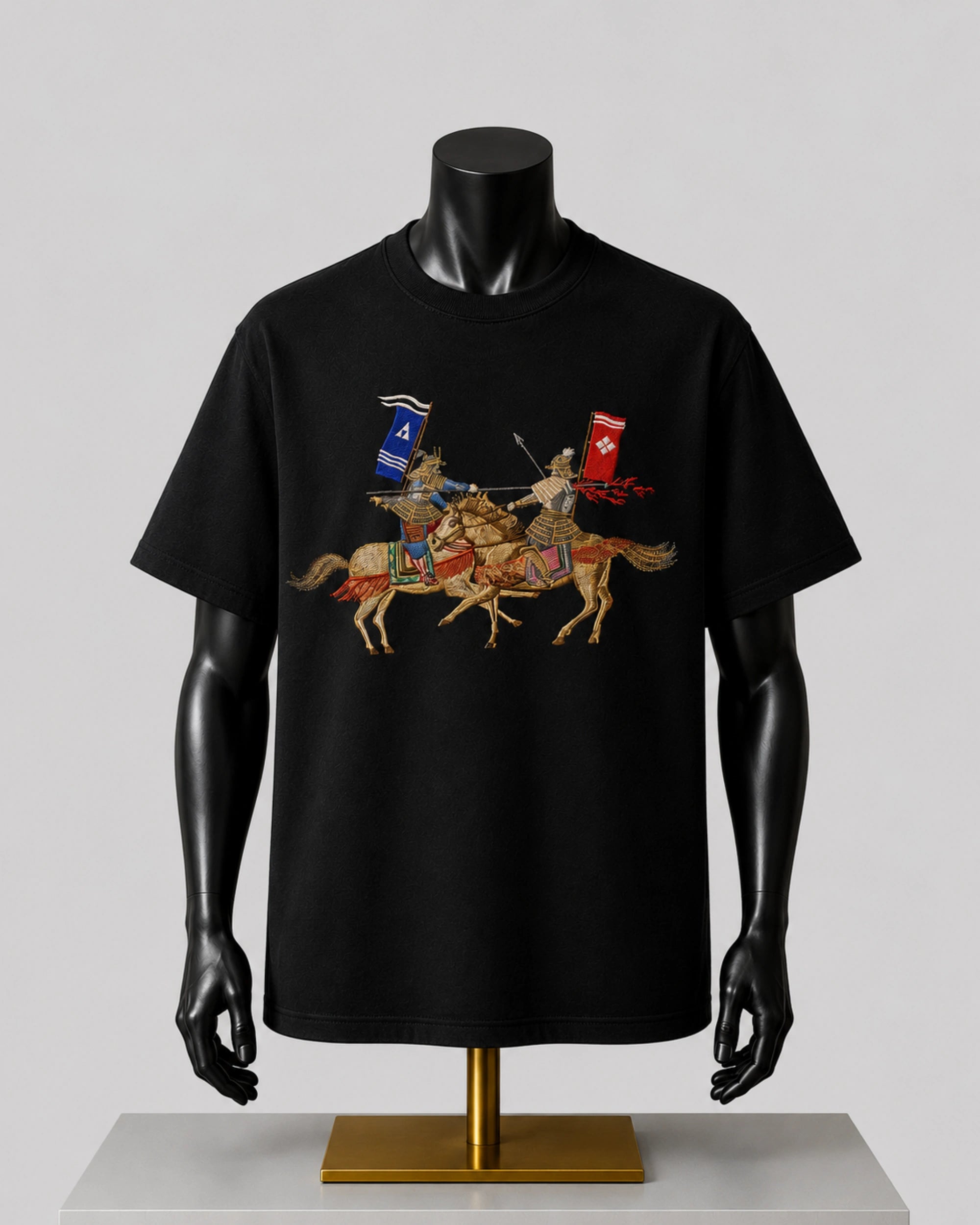 A black short-sleeve T-shirt displayed on a black mannequin torso with a gold stand, featuring a detailed graphic print of two medieval knights on horseback with red and blue banners against a light gray background.