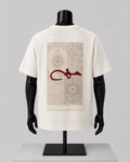 An off-white short-sleeve T-shirt displayed on a black mannequin torso, showing the back side with a large rectangular beige rug print and a red Arabic calligraphy graphic across the center.