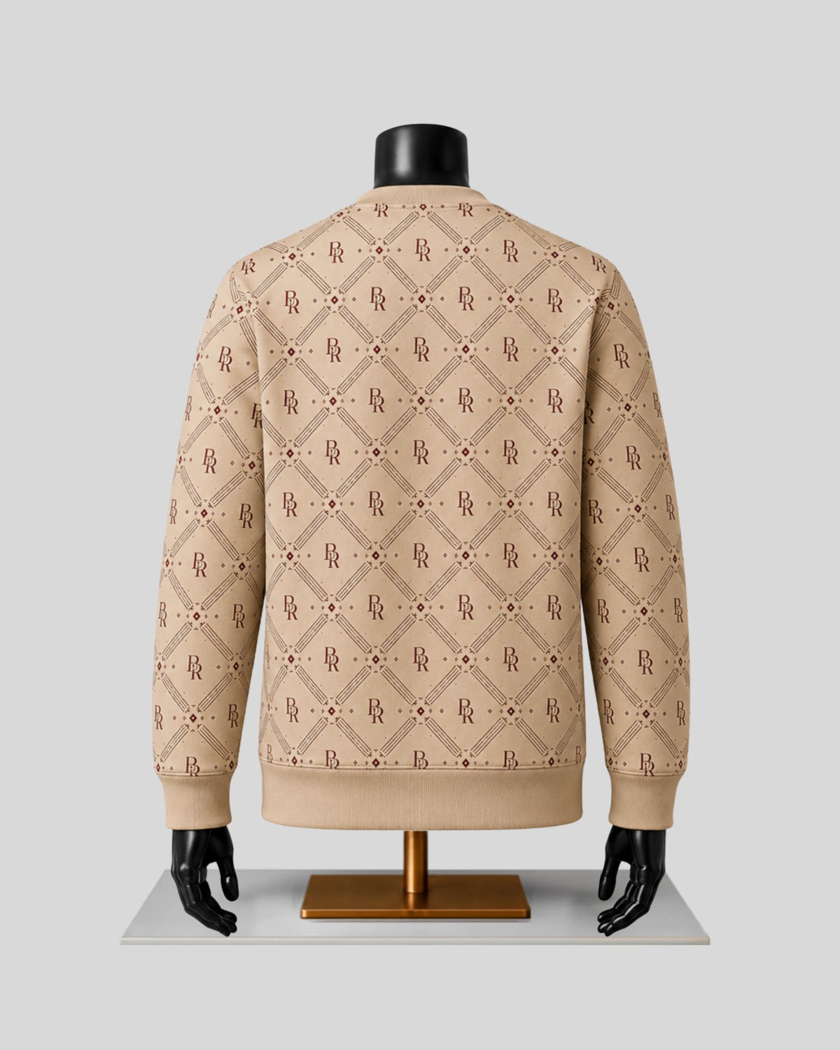 A beige knit sweater with an allover brown monogram pattern, displayed on a black mannequin torso with a gold stand against a light gray background.
