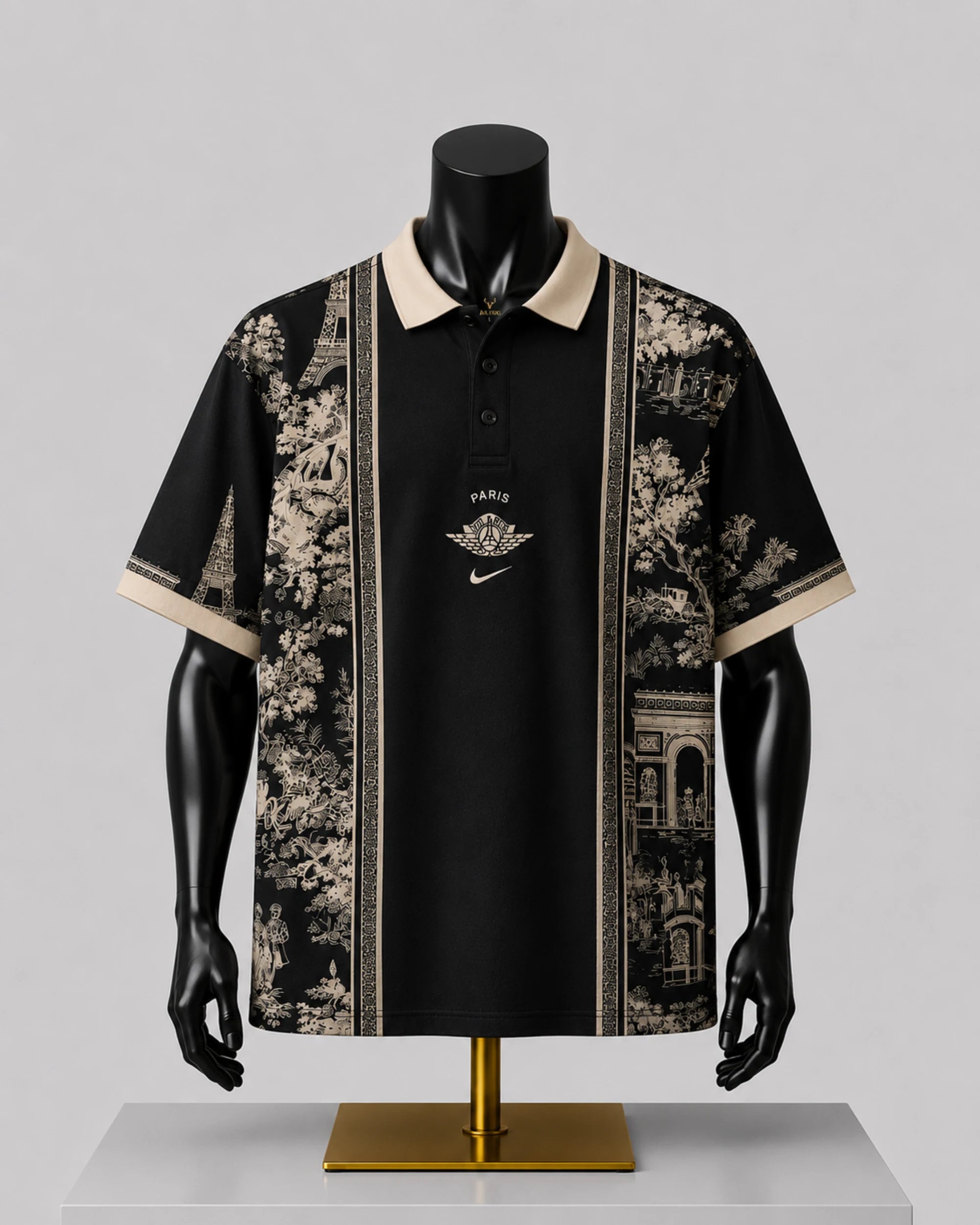 A black short-sleeve polo shirt with beige collar and sleeve trim, featuring beige scenic architectural and floral prints on the sides and a central gold-toned chest graphic, displayed on a black mannequin torso over a gold stand against a light gray background.
