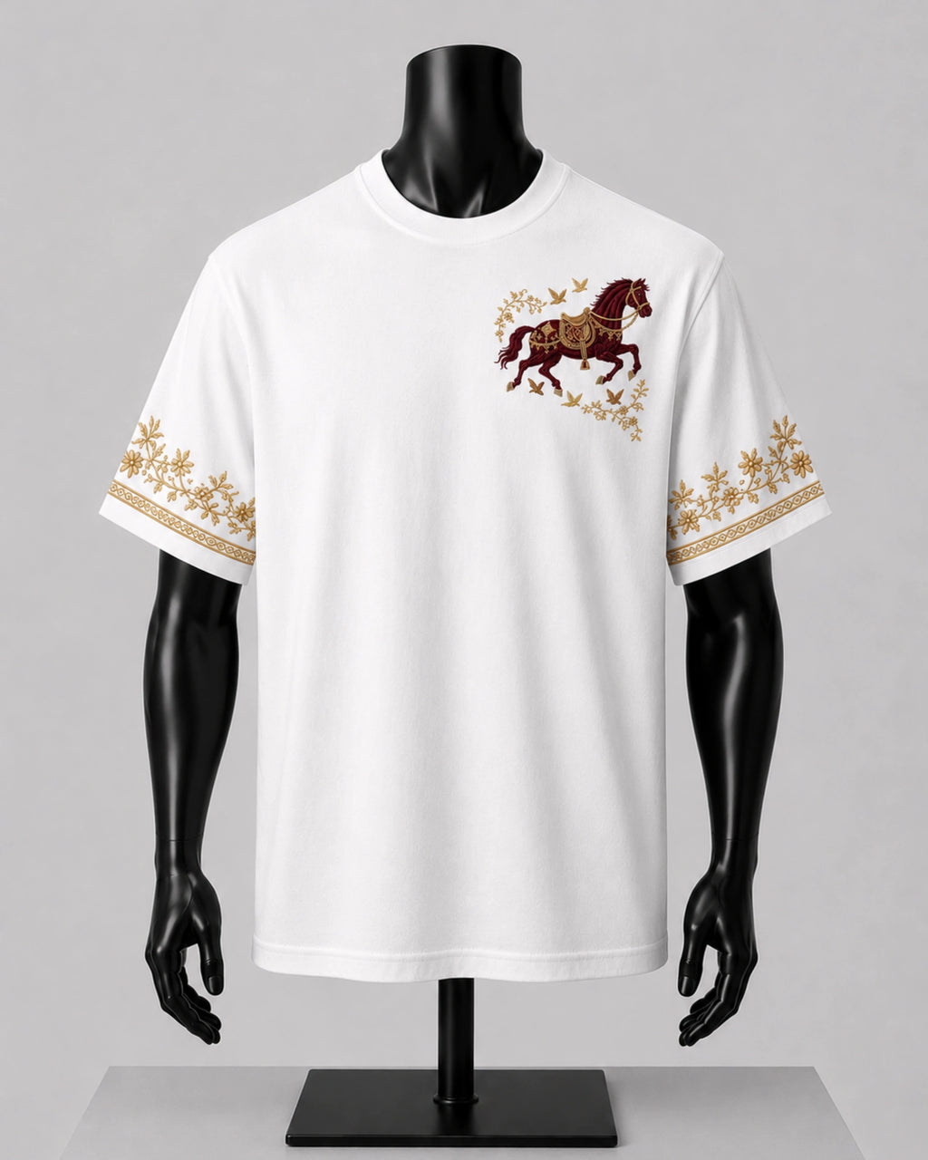 White short-sleeve t-shirt displayed on a black mannequin torso, featuring a brown and gold horse graphic on the left chest and matching gold floral border patterns on both sleeves.