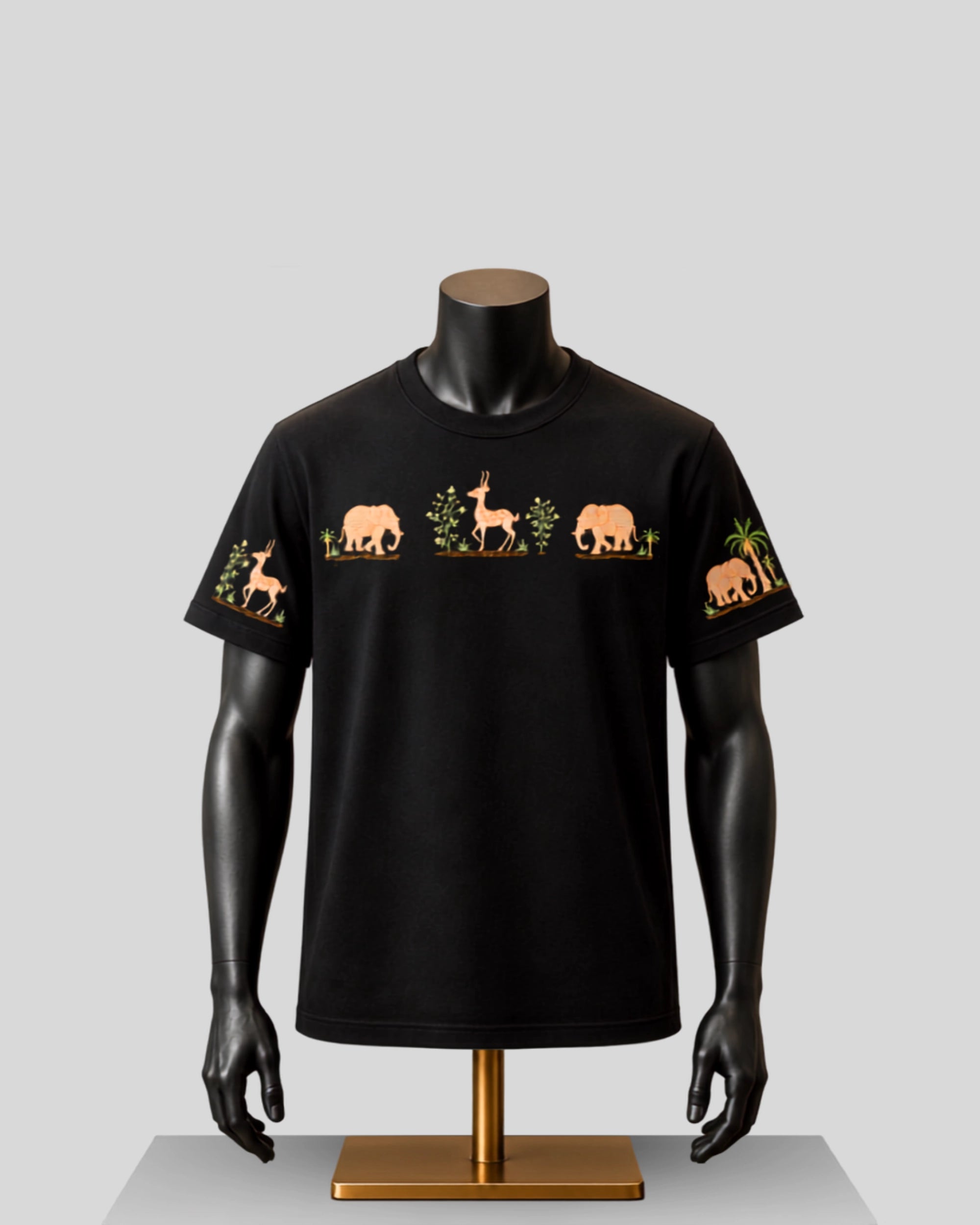A black short-sleeve crewneck t-shirt displayed on a black mannequin torso with a gold stand, featuring embroidered safari animal motifs including an elephant, gazelle, and palm tree on the chest and sleeves.
