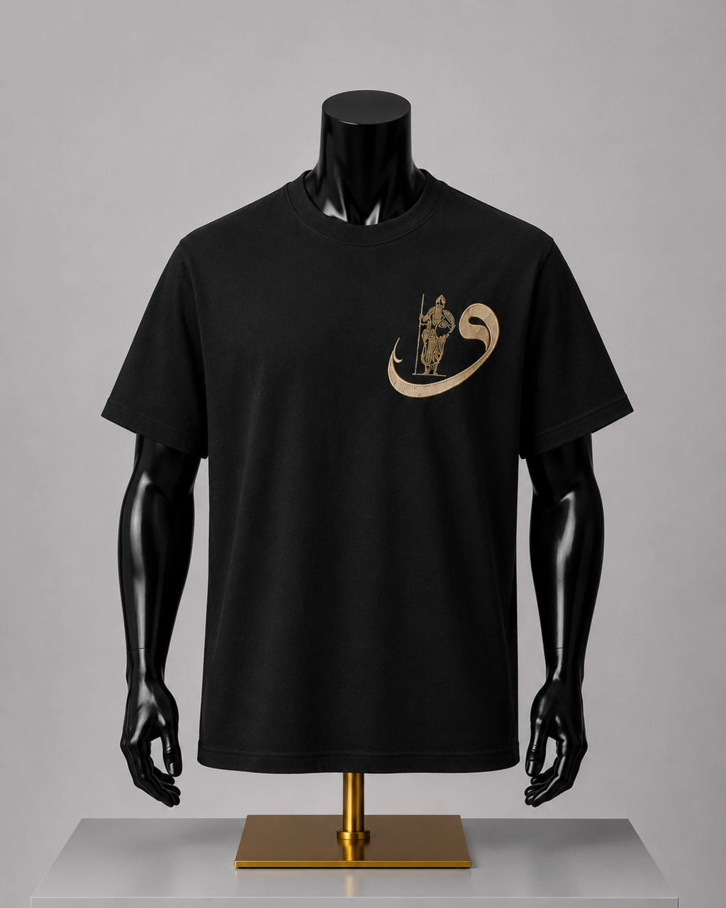A black short-sleeve crewneck t-shirt displayed on a black mannequin torso with a gold chest graphic, set against a neutral gray background.