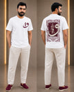 A man modeling a white short-sleeve T-shirt with a maroon crescent and star graphic on the chest, shown from both front and back. He is wearing light beige trousers and maroon slip-on shoes in a modern indoor studio setting with warm vertical light strips.